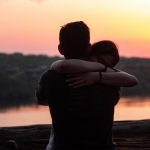couple hugging each other during sunset