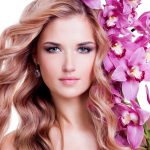 beautiful young pretty woman with healthy skin pink flowers close face isolated white