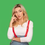 let39s think portrait smart pensive adult woman stylish overalls touching temple while thinking intensely musing pondering clever solution indoor studio shot isolated green background
