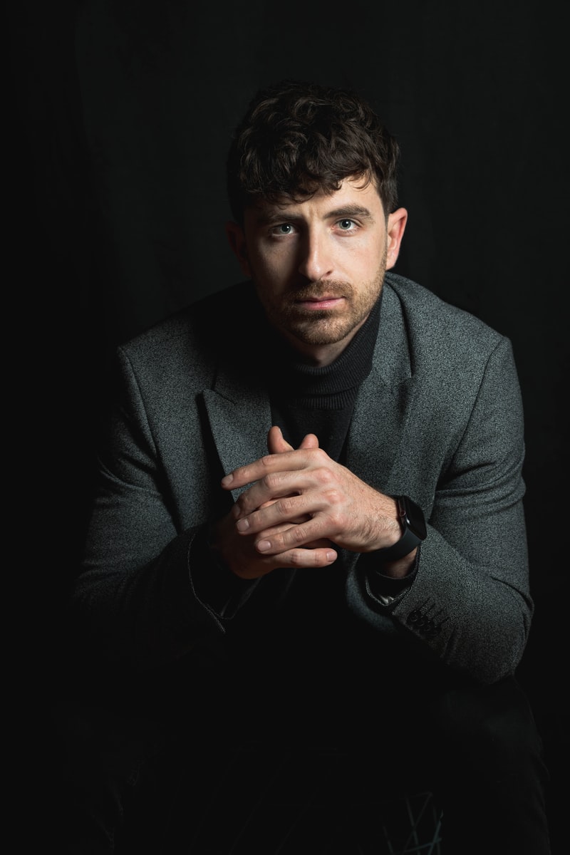 sitting man wearing gray suit blazer