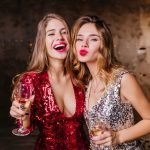 sensual woman red trendy dress happy laughing while her female friend posing with kissing face expression